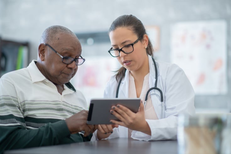 Doctor reviewing readings on tablet with patient