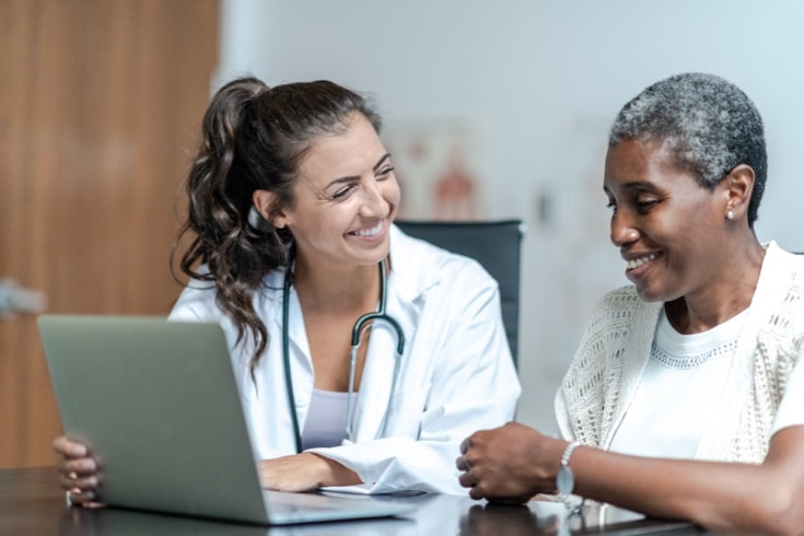 Doctor reviewing readings on laptop with patient